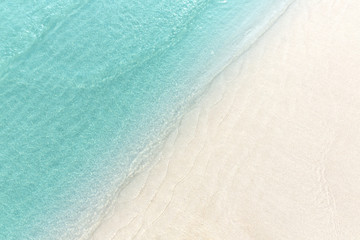 Obraz na płótnie Canvas Close up blue sea water waves on white sand beach,Beautiful blue sea beach with white sand, Beautiful blue ocean beach close up shot, Clean beach with blue sea in Thailand