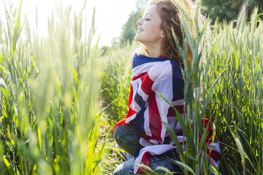 Smiling woman with Union Jack in nature