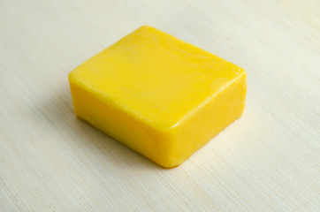 Soap bar flavor with mango ingredient isolated on wooden board b