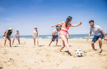 Poster Friends playing football on the beach © oneinchpunch