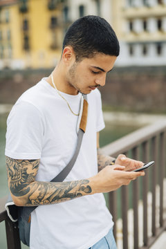 Young man outdoors looking at cell phone