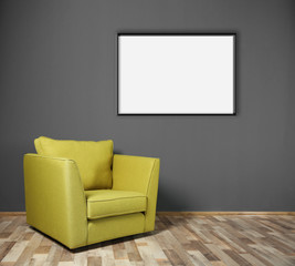 Green armchair and empty picture frame on grey wall background
