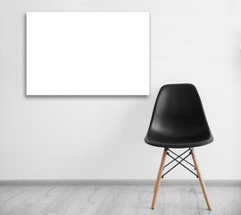 Black chair and empty picture frame on wall background