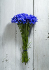 Blue wildflowers on a wooden background