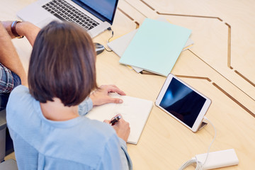 over the shoulder shot of woman unlocking her tablet