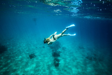 Woman snorkeling underwater at a tropical island resort