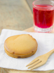custard cake and iced red soda on wood table