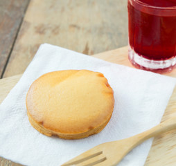 custard cake and iced red soda on wood table