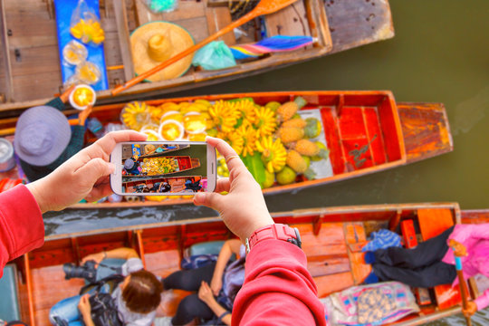 Smartphone photographing Damnoen Saduak floating market in Ratchaburi near Bangkok, Thailand