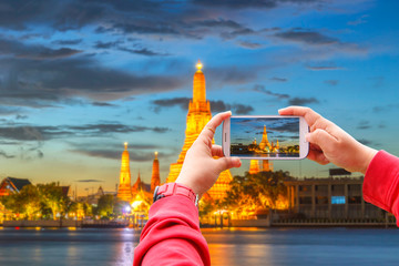 Fototapeta premium Smartphone photographing Wat Arun Buddhist religious places in twilight time, Bangkok, Thailand