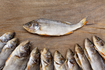 Many dried perch on a wooden background.