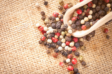 Red, white and black pepper in a spoon