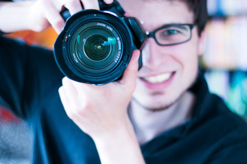 Junger Mann fotografiert mit Spiegelreflexkamera