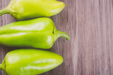 Three green and yellow peppers in a row