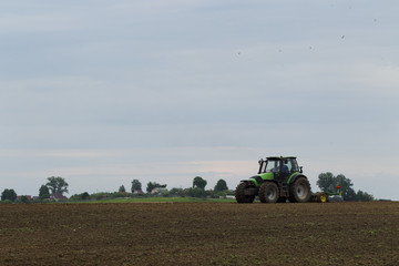 The tractor in the field on agricultural operations