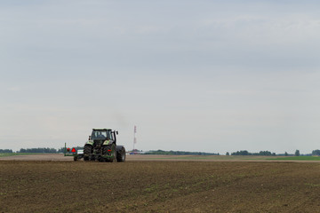 Fototapeta premium The tractor in the field on agricultural operations