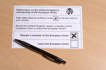 Completing a postal ballot paper with a cross in a box to stay in the European Union.