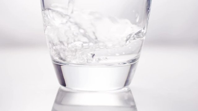 4K Water filling up the top of a glass, in slow motion