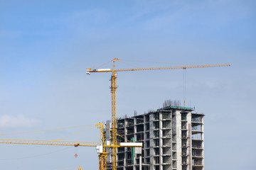 the construction site and crane with the blue sky,the under construction building site with the crane and blue sky