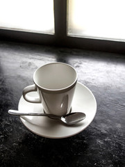 Empty white cup on black floor