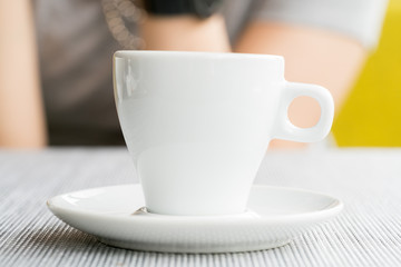 espresso coffee in thick white cup in a cafe, super shallow doc
