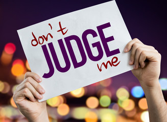 Don't Judge Me placard with night lights on background