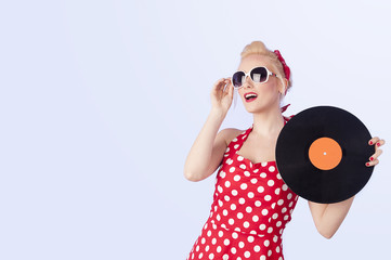 Pin-up girl in vintage dress holding a vinyl record 