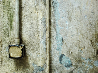 Vintage old grime wall texture with chipped peeling paint and electrical tubing