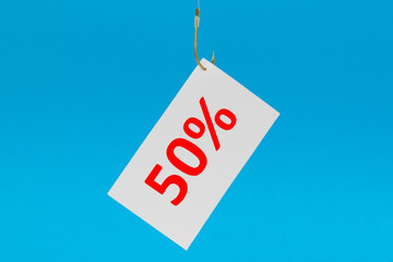 Preisschild am Haken vor blauem Hintergrund