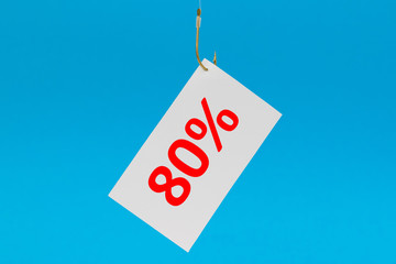 Preisschild am Haken vor blauem Hintergrund