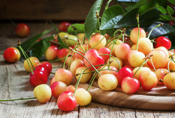 Ripe yellow pink cherry on an old wooden table, harvested crops,