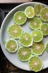 Slice of peeled green fresh lime on white plate.
preparing for cooking in Thai style
or to make fresh scent and be deodorizer for cozy Thai massage spa resort business.
