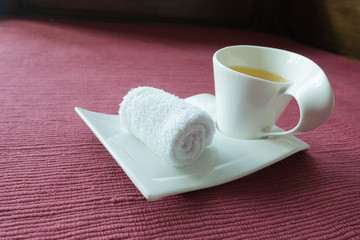 white scented rolled wet towel and hot Thai herb tea on to welcome a guest to thai aroma massage resort spa, Thailand.
