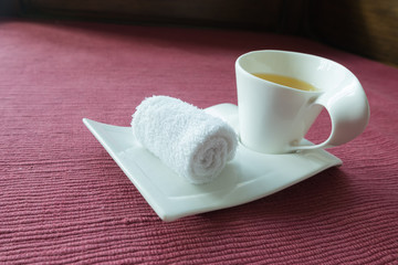 white scented rolled wet towel and hot Thai herb tea on to welcome a guest to thai aroma massage resort spa, Thailand.
