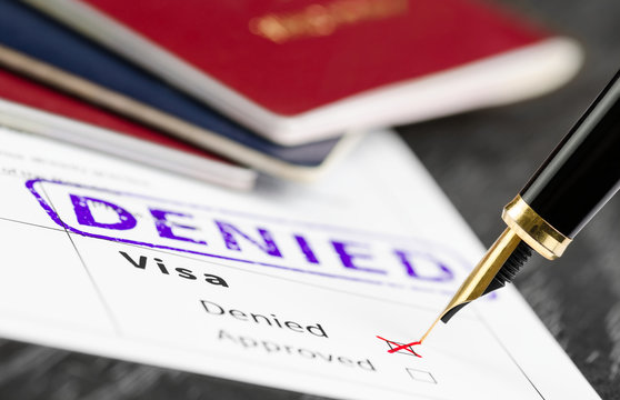 Visa application denied, close up shot of a form, passports and pen.