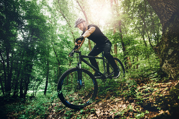 Fototapeta na wymiar Professional mountain bike cyclist riding trail in forest, details of sports