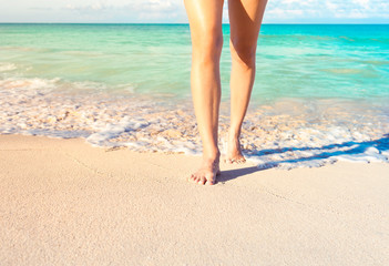 Woman walking on a beautiful tropical white sand beach. 