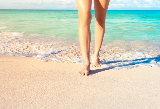 Woman walking on a beautiful tropical white sand beach. 