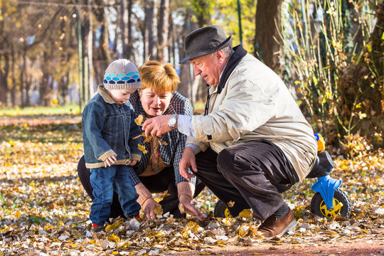 grandparents playing with grandson in a park