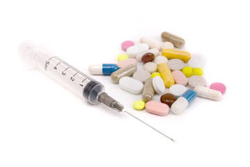 Medicine pills and syringe on a white background