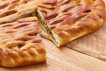 A piece of pie with a filling of apples on a wooden table
