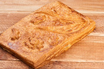 The flaky meat pie on a wooden table