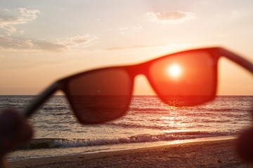 Fototapeta na wymiar Sunglasses on a sunset sea background