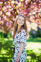 Fototapeta premium Beautiful young woman in blooming spring park