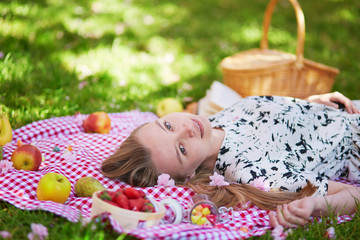 Obraz na płótnie Canvas Beautiful young woman having picnic in park
