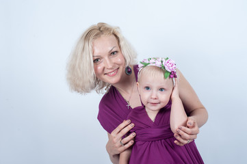 Fototapeta na wymiar Blonde mom and daughter in Studio on white background