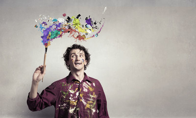 Fototapeta premium Man artist painting with brush