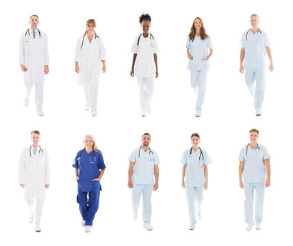 Doctors With Medical Workers Walking Against White Background