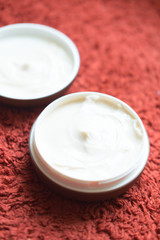 Hair wax and clay in tubs on red background