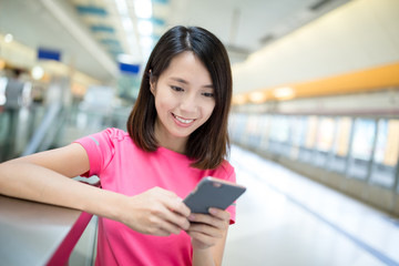 Woman use of mobile phone in train platform